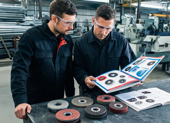 Technician reviewing grinding wheel selection with a shop operator